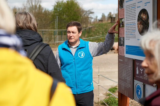 Patrick Boncourt bei einer Führung vor einem Schild im Tierschutzzentrum Weidefeld